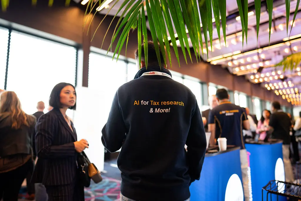 SavvyWise team member at a conference wearing AI for Tax Research apparel